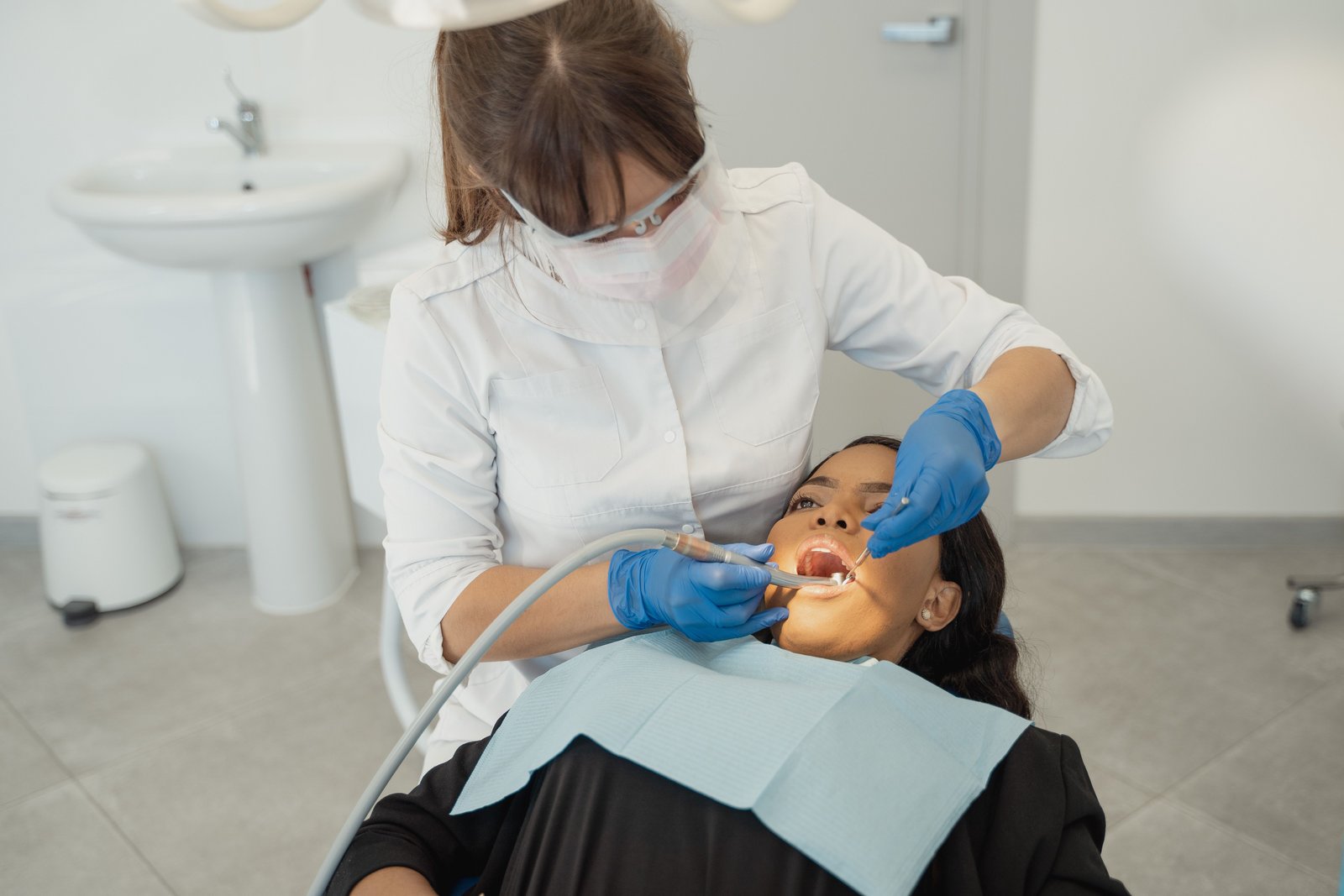 A dentist treating a patient in a bright treatment room